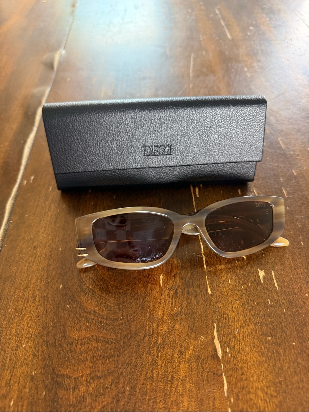 DEZI cuffed square frame sunglasses with asymmetrical piercings.